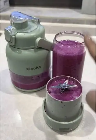 Two blended fruit smoothies poured from a Xiaoks portable blender, standing on a kitchen surface